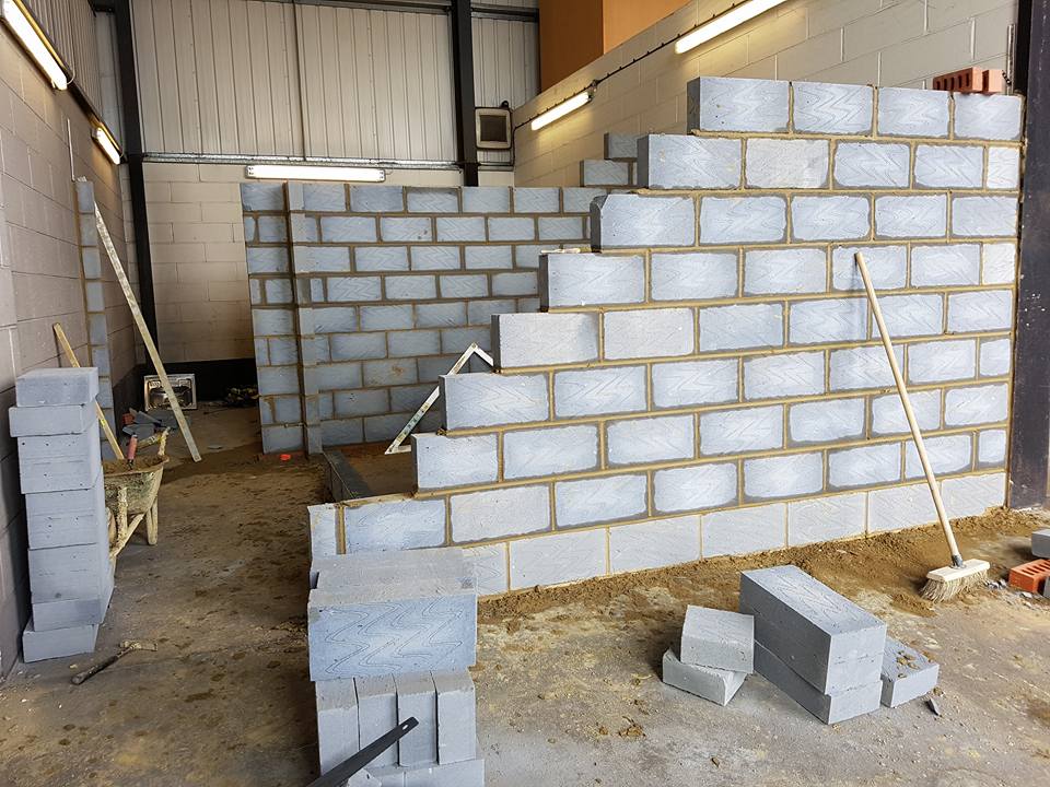 Professional tiler working on bathroom tiling during a house renovation